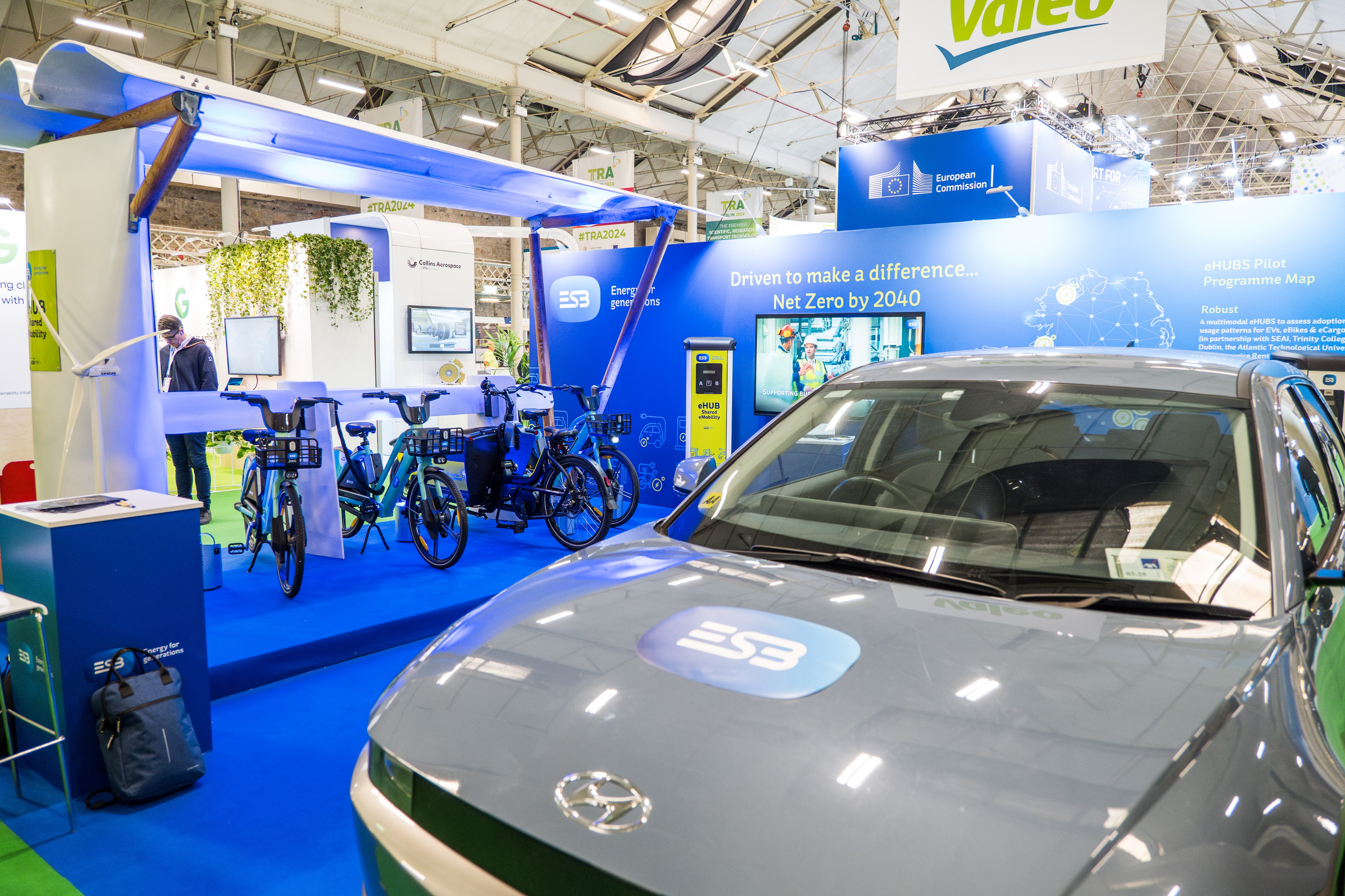 An exhibition stand with an ESB branded car and three e-bikes. 