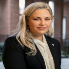 Karen Halpenny, white woman with long blonde hair and wearing a black jacket and white shirt