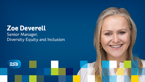 A white woman with long blond hair smiling against a blue branded background with coloured blocks