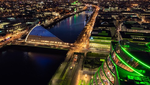 A landscape image of Dublin city at night with the large Samuel Beckett bridge most visible