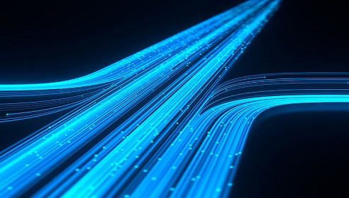 Image of bright blue fibre optic cables with a black background, to illustrate fibre connectiving and data.