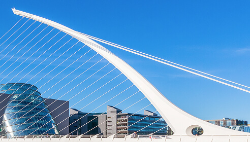 The Samuel Beckett bridge with the Convention center and other grey office buildings beisde it