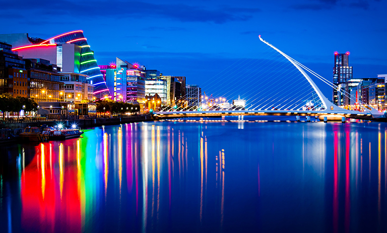 Photograph of Dublin city at night, showcasing illuminated buildings and streets, representing connectivity and urban infrastructure.
