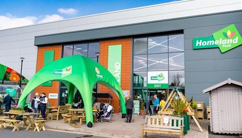 Picture of a Homeland retail shop with garden furniture  and green canopy outside.